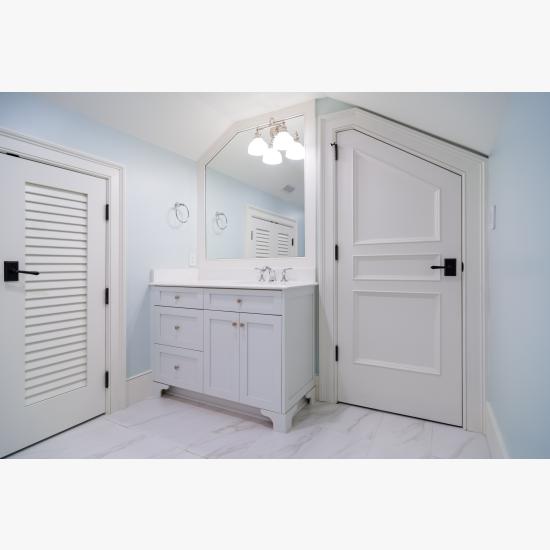 A clipped-corner TS3070 door fits the unique ceiling of this attic powder room. Pair of LVR1000 doors to the left.