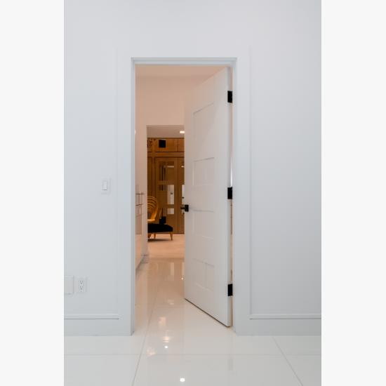 A TM9420 door in MDF open to a luxurious walk-in closet.