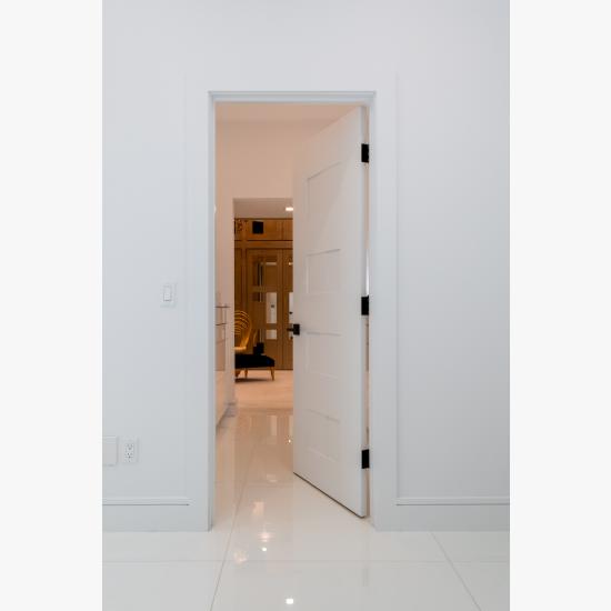 A TM9420 door in MDF open to a luxurious walk-in closet.