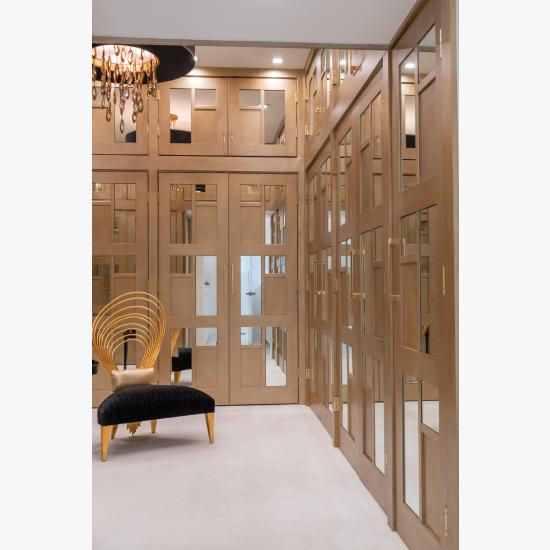 The designer added glamour to this walk-in closet by custom applying plant-ons and mirrors to TS3000 doors in MDF.