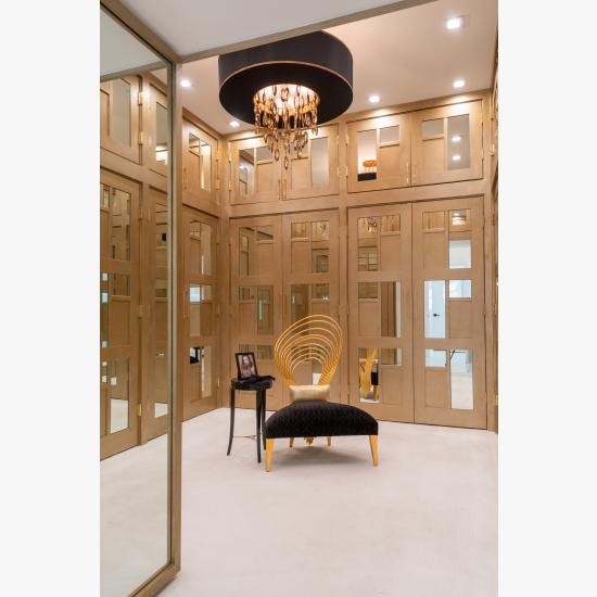 The designer added glamour to this walk-in closet by custom applying plant-ons and mirrors to TS3000 doors in MDF.