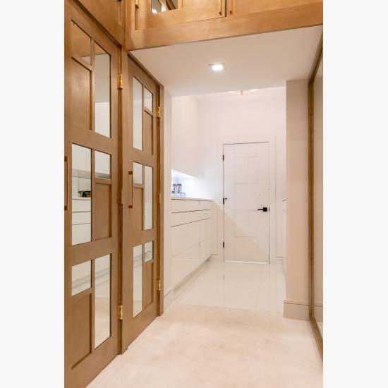 The designer added glamour to this walk-in closet by custom applying plant-ons and mirrors to TS3000 doors in MDF.