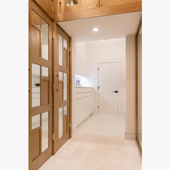 The designer added glamour to this walk-in closet by custom applying plant-ons and mirrors to TS3000 doors in MDF.