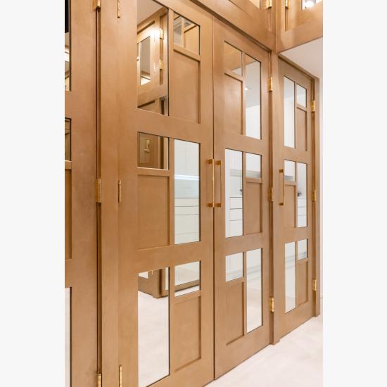 The designer added glamour to this walk-in closet by custom applying plant-ons and mirrors to TS3000 doors in MDF.