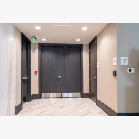 Condominium tower featuring TS1000 doors, in rift sawn white oak with Quirk (QM) moulding and Flat (C) panel in lobby.