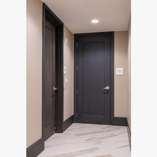 Condominium tower featuring TS1000 doors, in rift sawn white oak with Quirk (QM) moulding and Flat (C) panel in lobby.