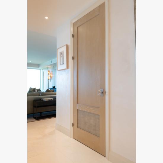 This modified TS2210 door, in wire-brushed plain sawn white oak with customer applied ceruse finish and Shagreen Grey Oyster leather, features olive knuckle hinges.