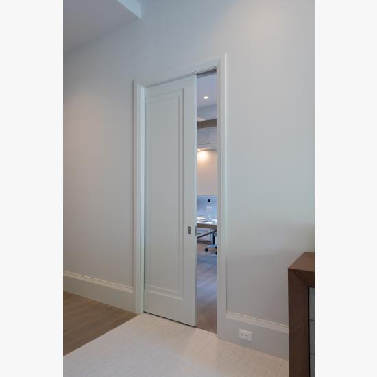 A TS1000 pocket door, in MDF with Miracle (MR) moulding and flat (C) panel, opens from the master bedroom to a private office.