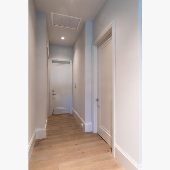 A hallway with TS1000 doors, in MDF with Miracle (MR) moulding and Flat (C) panel lead downs to the garage.