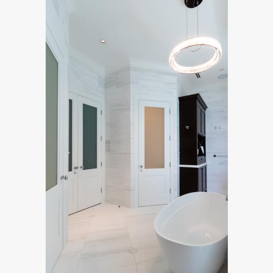 A master bath features TS2060 doors in MDF with Roman Ogee (OG) sticking, Raised (A) panel and Frosted Glass. The bottom panels have been replaced with false louver panels.