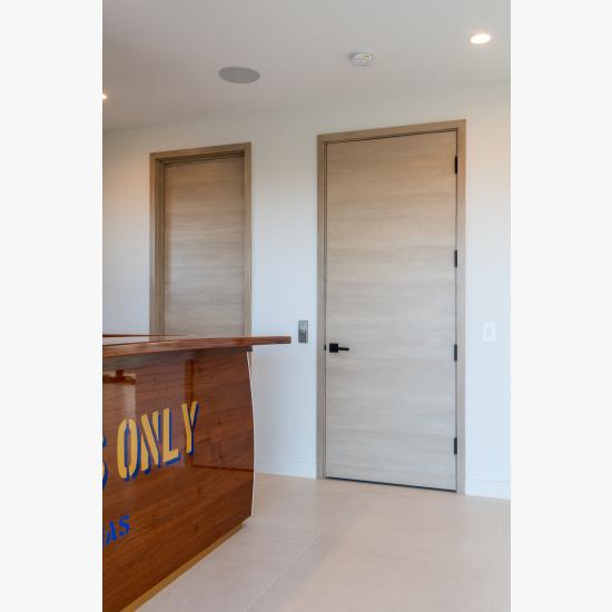 An upstairs lounge features TMF1000 flush doors in quarter sawn white oak with a custom ceruse finish.