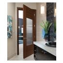 A TM9250 door, in walnut with Nutmeg stain and Groove glass, divides a bathroom from this contemporary study.