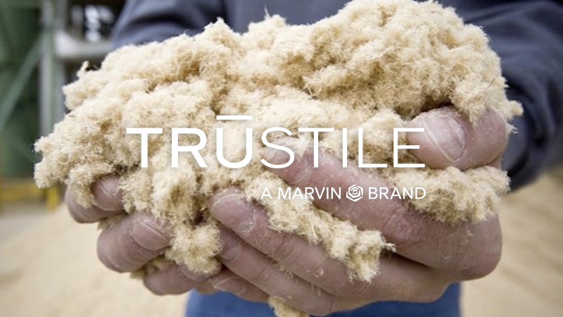 Hands holding a clump of wood fibers before being made into MDF