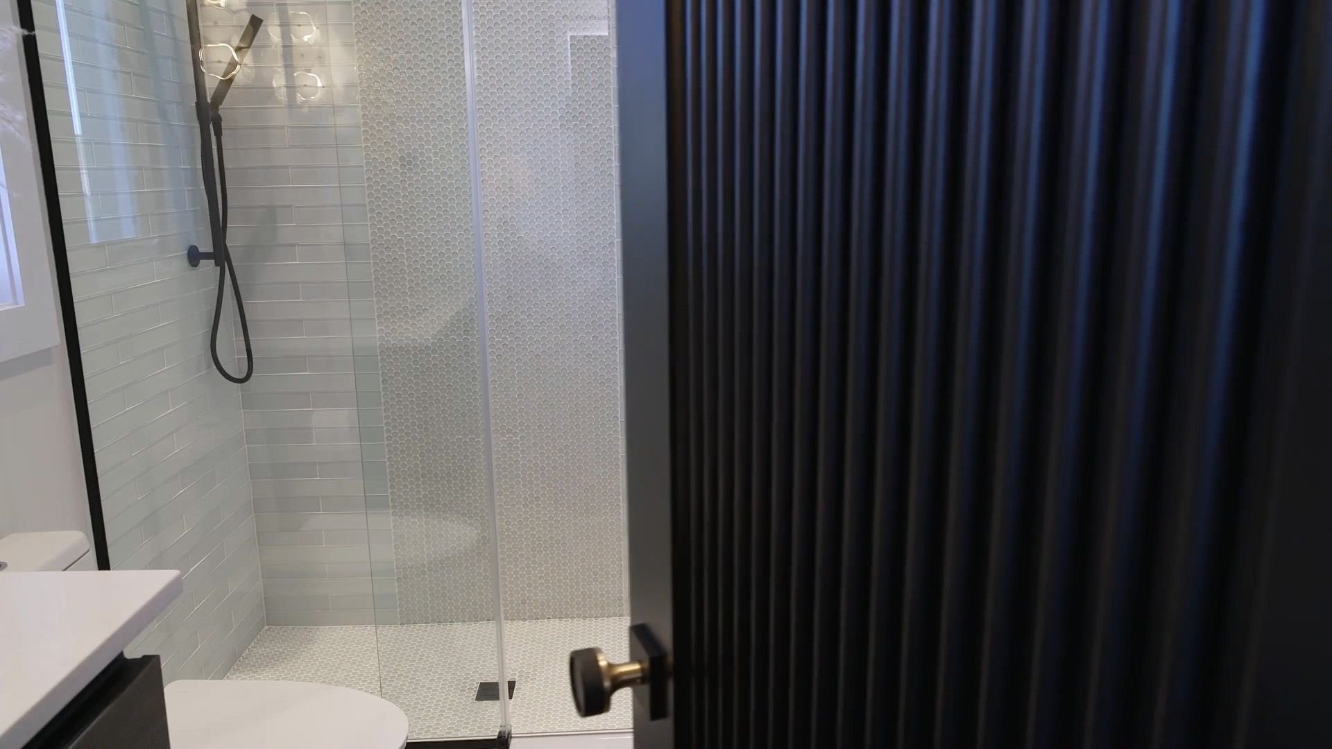 Tambour door opens to reveal a bathroom with contemporary shower