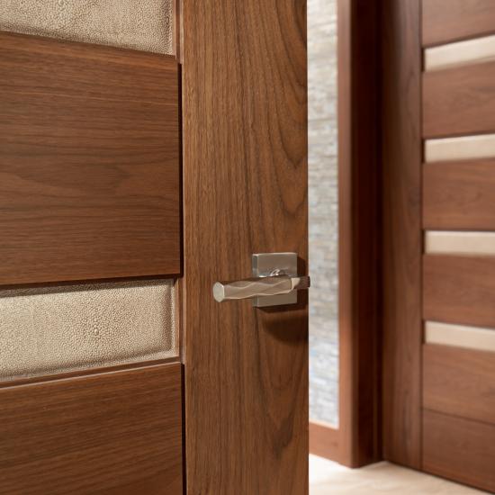 A TM9340 door, in walnut with Nutmeg stain and Shagreen Café Latte leather, opens to a large study which doubles as a guest room.