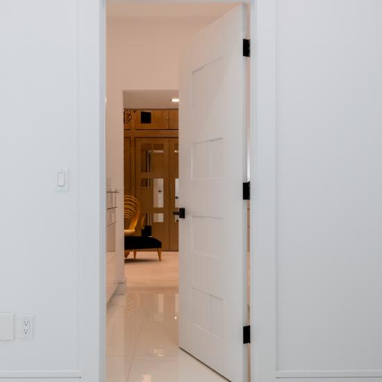 A TM9420 door in MDF open to a luxurious walk-in closet.