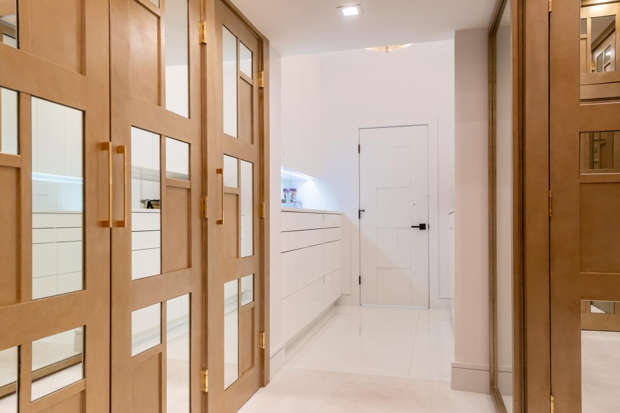 The designer added glamour to this walk-in closet by custom applying plant-ons and mirrors to TS3000 doors in MDF.