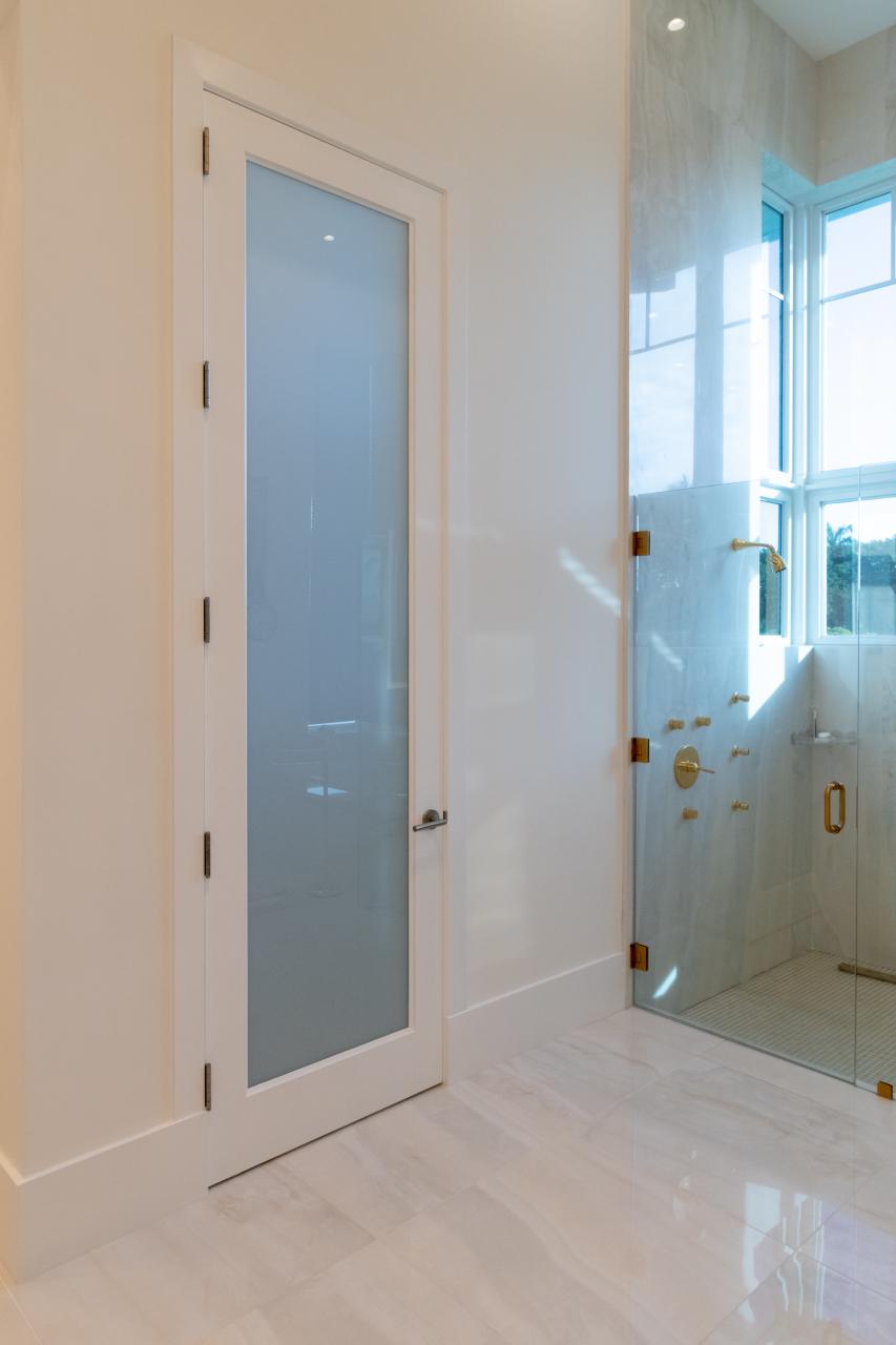 This master bath features 10' tall TS1000 door in MDF with One Step sticking and White Lami glass