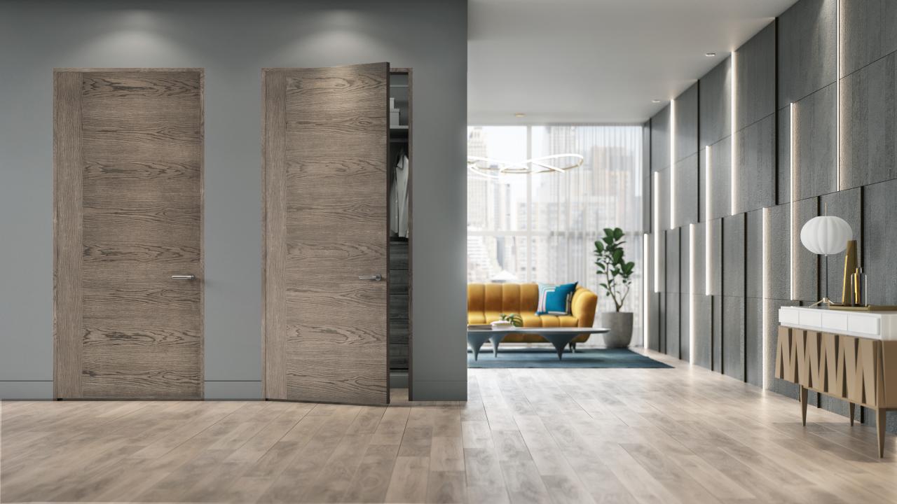 A living room features TMF1001 sketch face flush wood doors in White Oak with Grey Mist stain.