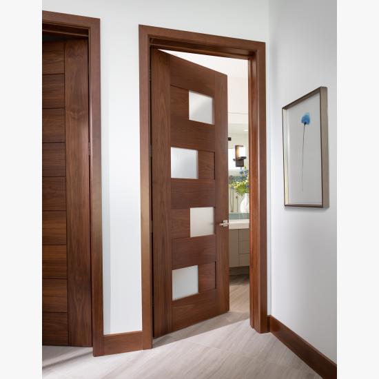 This guest room features a TM9430 door, in walnut with Nutmeg stain and Flow glass, that opens to an adjacent bathroom
