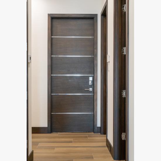 A TMIR6000 door in mahogany with ½" bright stainless steel inlay opens to the attached garage. Builder provided stain finish.